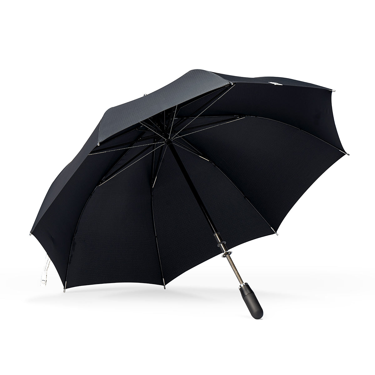 underside view of a handmade manual open luxury golf umbrella with a matte black TPR grip handle, Teflon-coated fine denier woven black polyester twill canopy, chrome trim, carbon fiber shaft, fiberglass ribs, and a reflective strap embroidered with “ShedRain Stratus.”