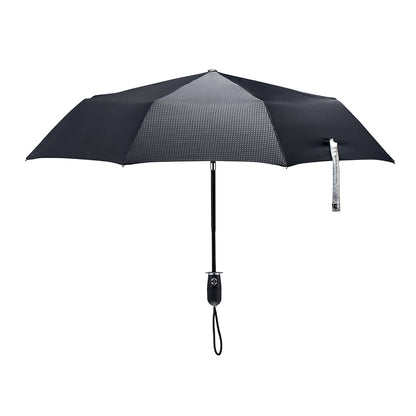 straight on view of a handmade auto open auto close open compact luxury umbrella with a matte black TPR grip handle containing a chrome double arrow button, detachable waxed cotton wrist strap, Teflon-coated fine denier woven black polyester twill canopy, chrome trim, Trilobe aircraft aluminum shaft, fiberglass ribs, and a reflective strap embroidered with “ShedRain Stratus.”